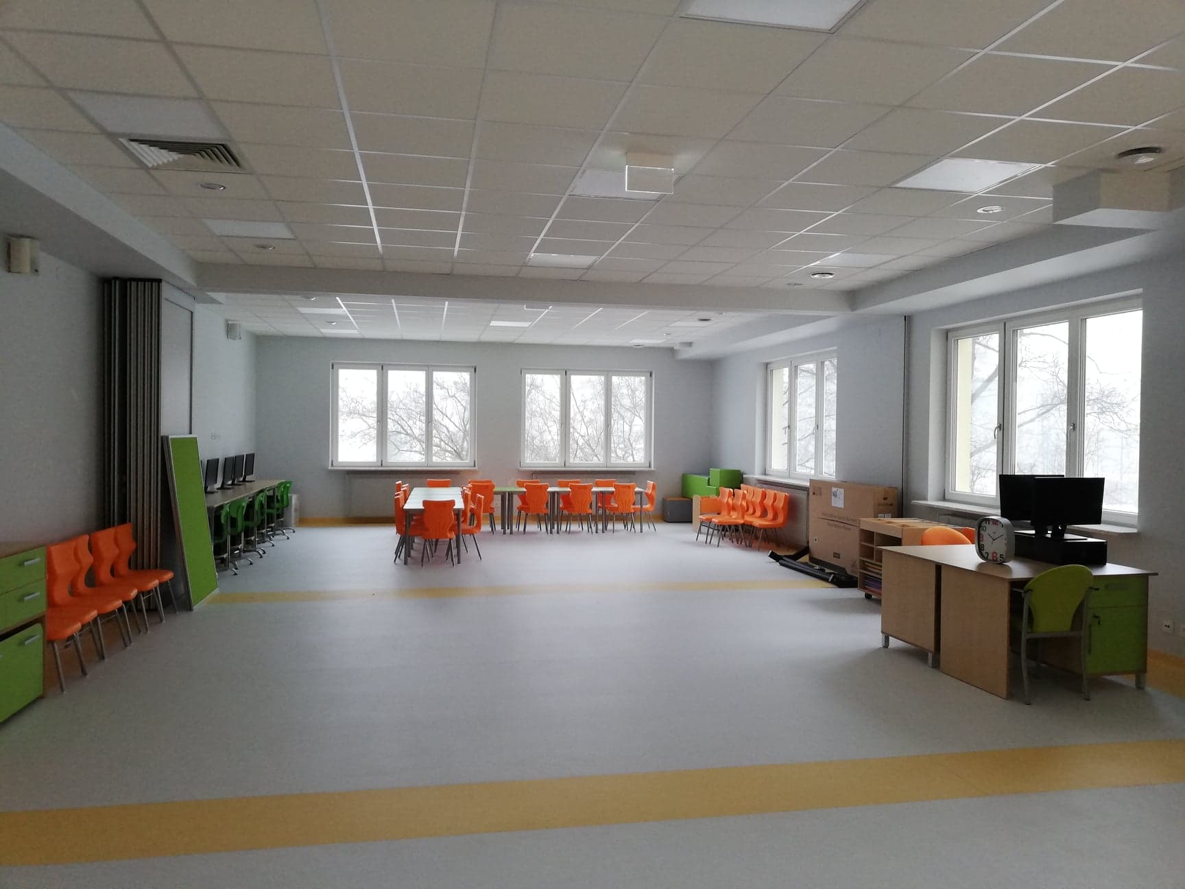 nowa świetlica z kolorowymi stolikami i stanowiskami komputerowymi